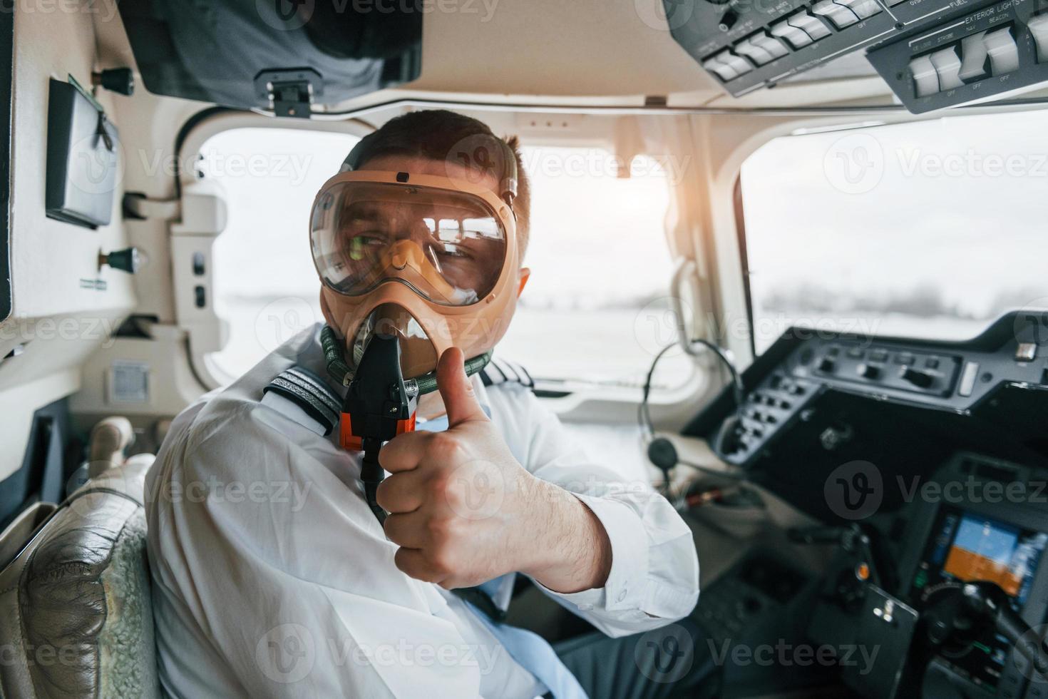 In oxygen mask. Pilot on the work in the passenger airplane. Preparing for takeoff photo