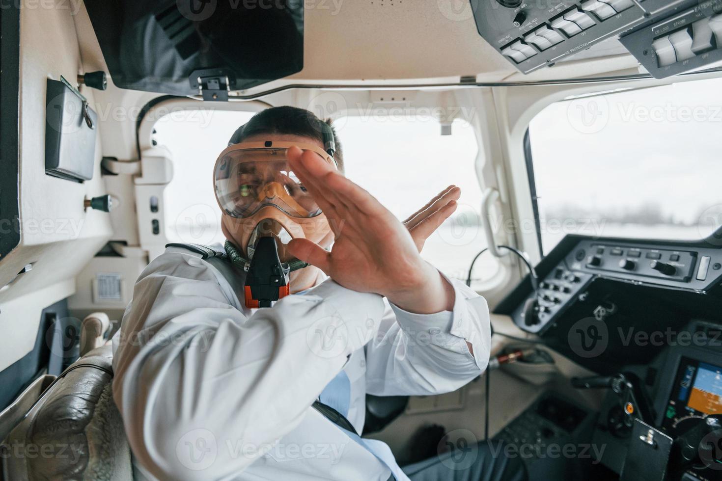 In oxygen mask. Pilot on the work in the passenger airplane. Preparing for takeoff photo