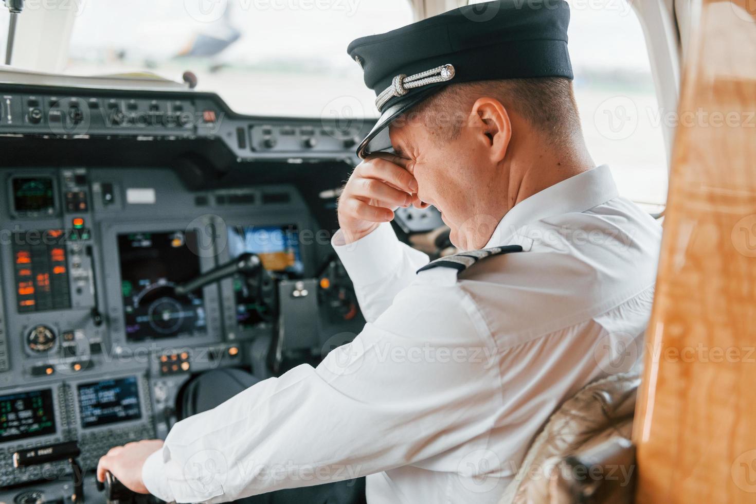 Pilot on the work in the passenger airplane. Preparing for takeoff photo