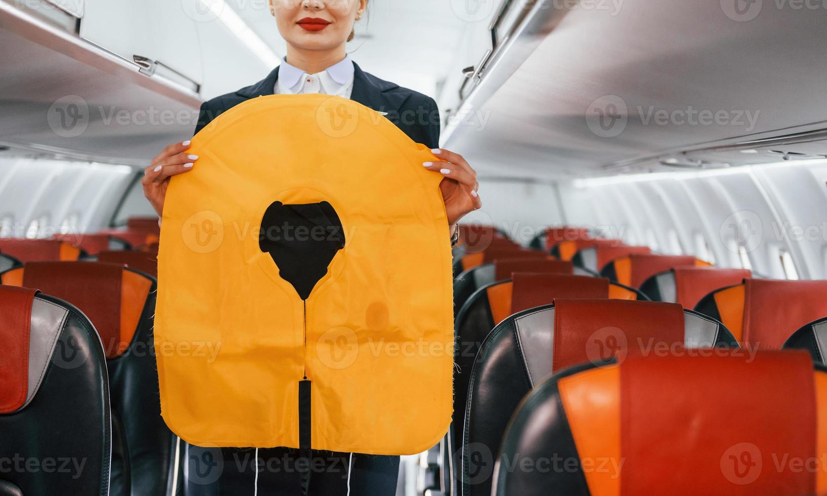 Safety instructions. Young stewardess on the work in the passanger airplane photo
