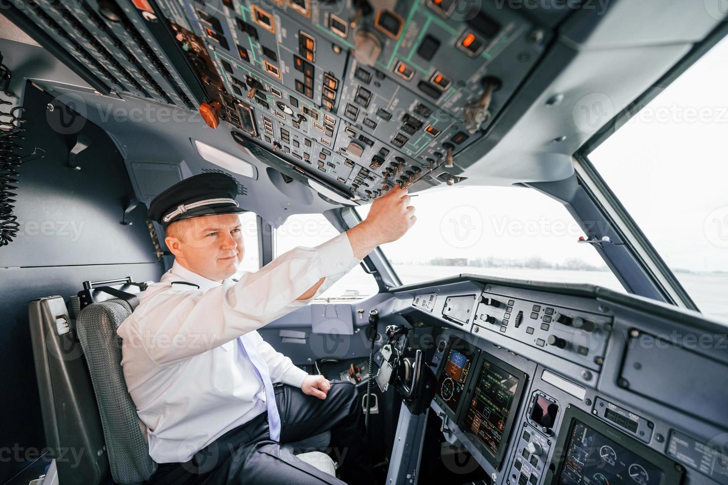 Control of the flight. Pilot on the work in the passenger airplane. Preparing for takeoff photo