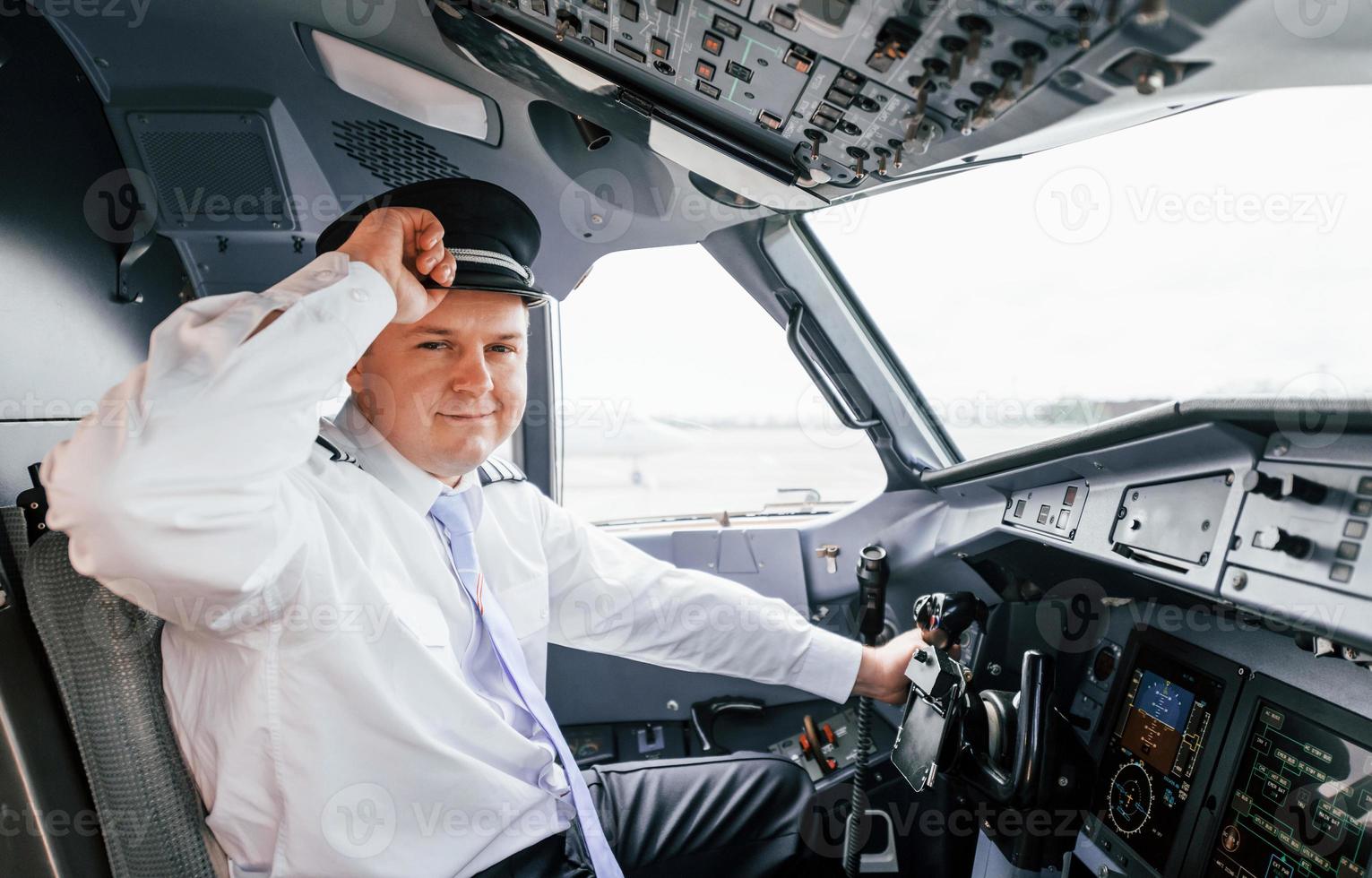 Pilot on the work in the passenger airplane. Preparing for takeoff photo