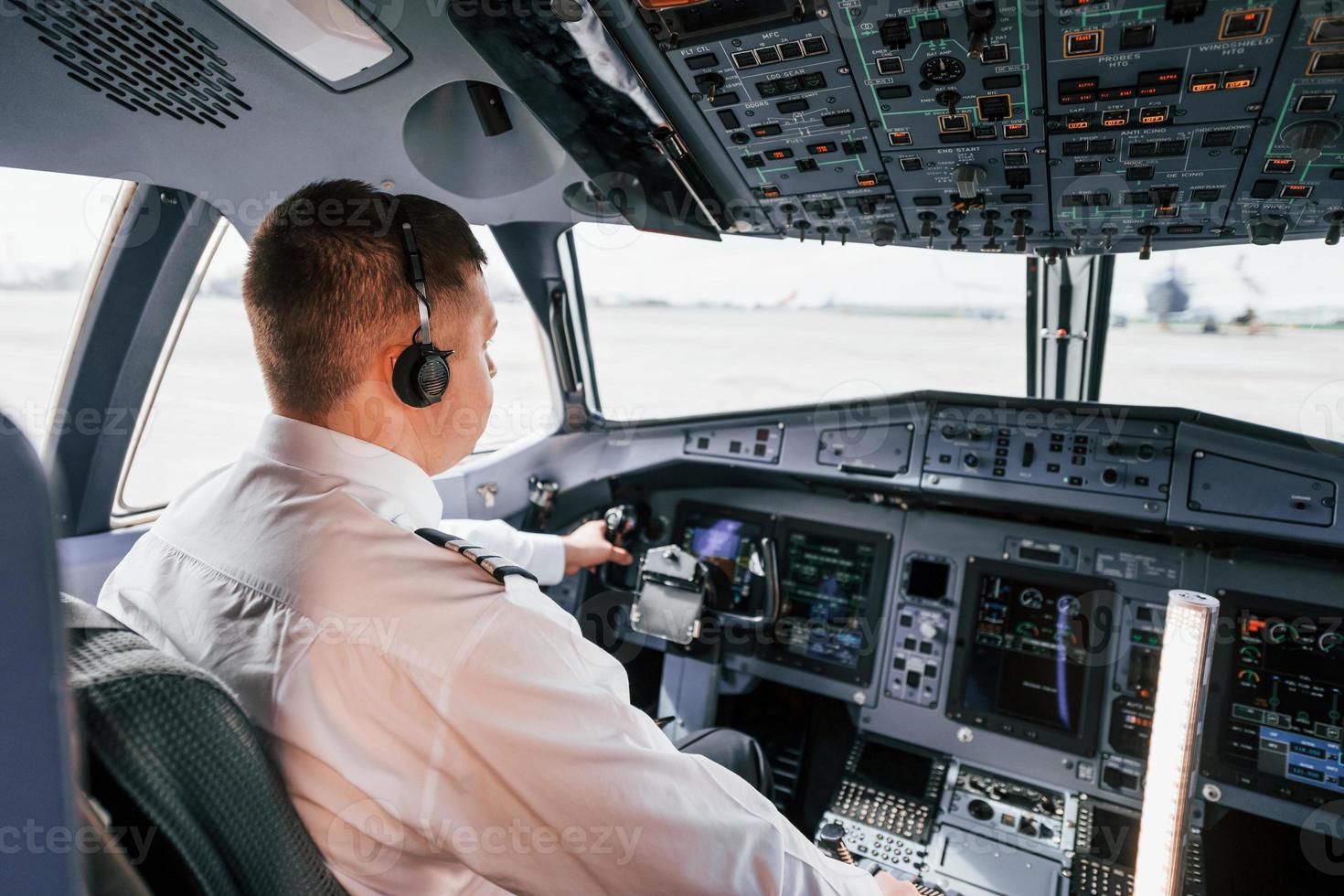 Pilot on the work in the passenger airplane. Preparing for takeoff photo