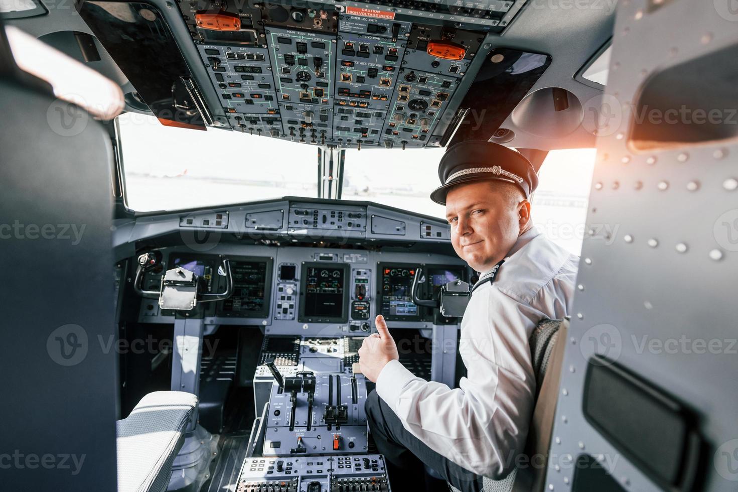 Looks behind. Pilot on the work in the passenger airplane. Preparing for takeoff photo