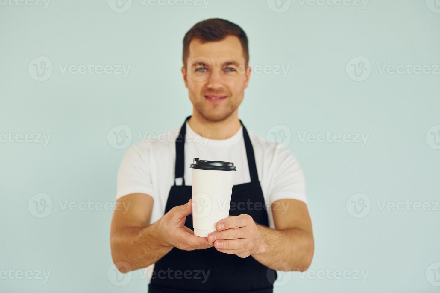 Man in uniform standing in the studio with drink in hands photo