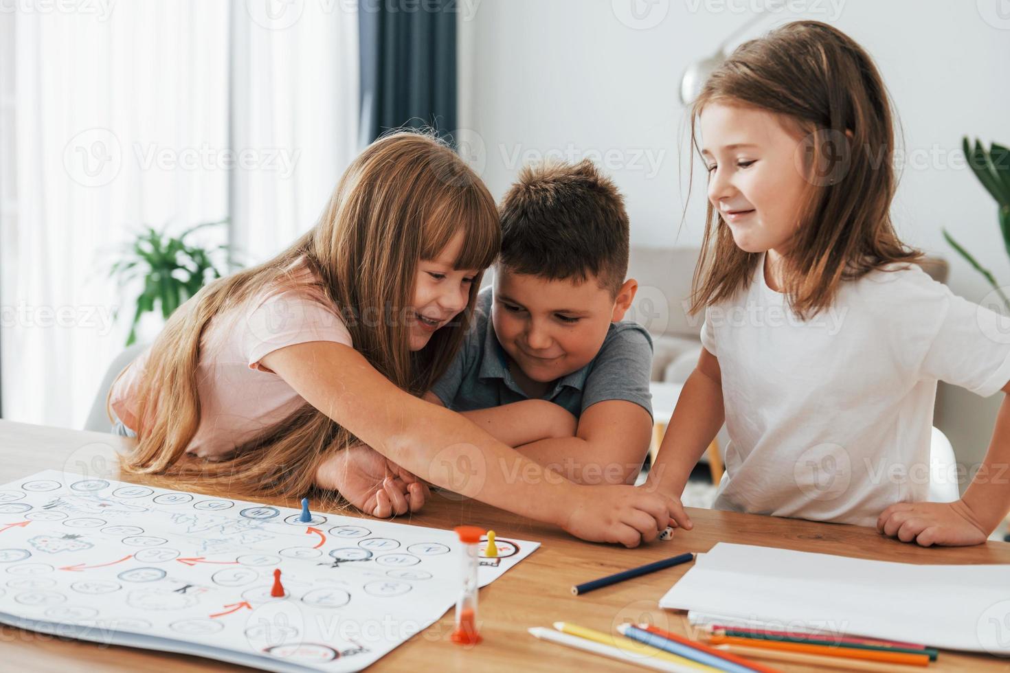 Playing game together. Kids having fun in the domestic room at daytime photo