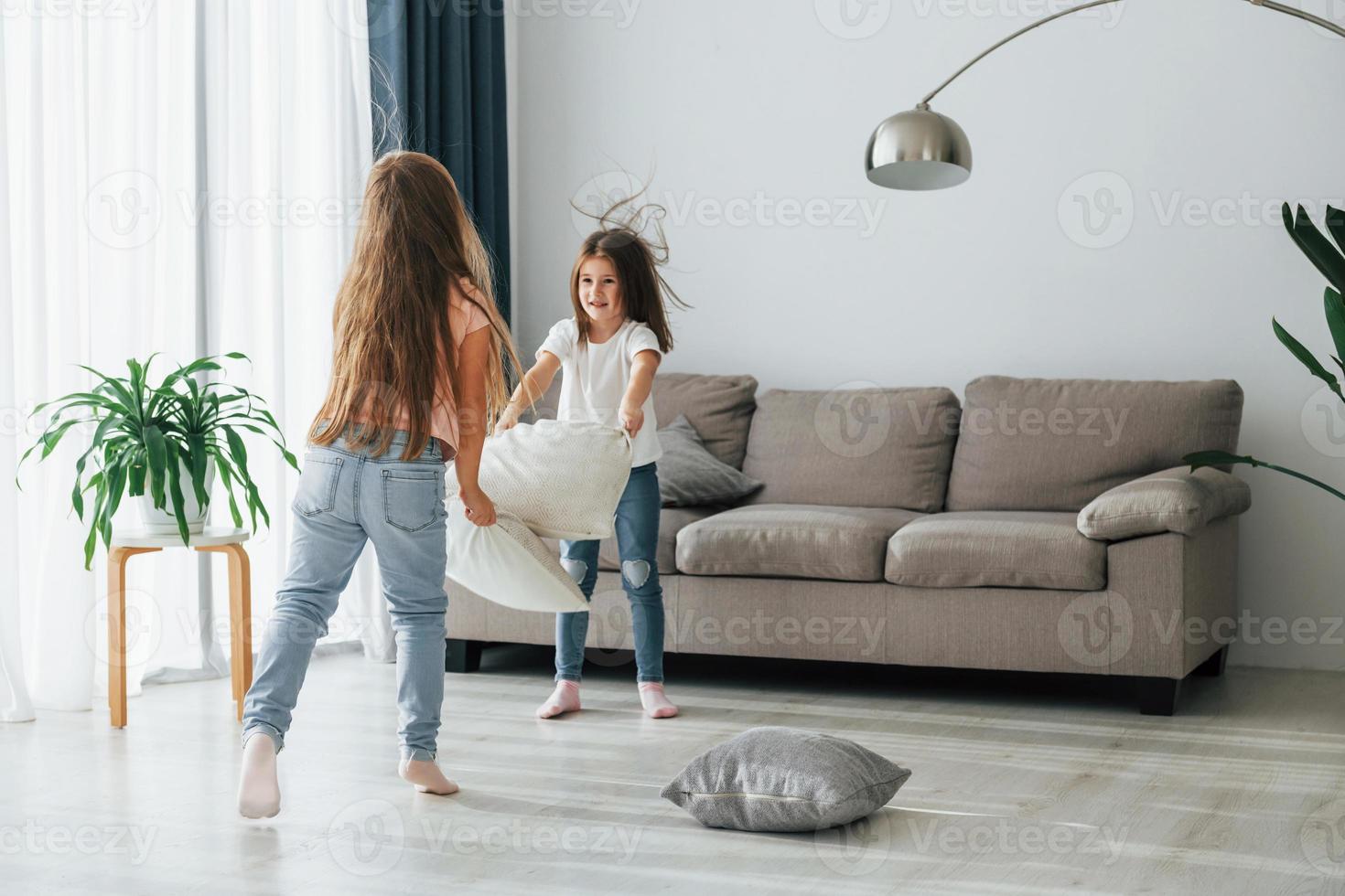 Active weekend time spending. Kids having fun in the domestic room at daytime together photo