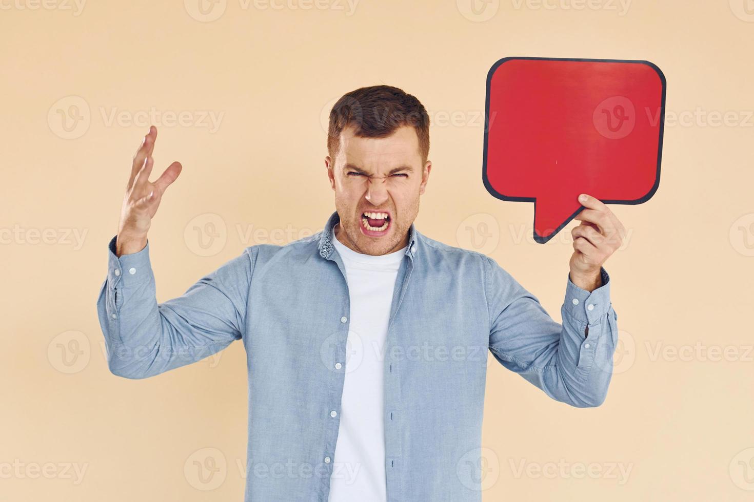 Angry and mad. Man standing in the studio with empty signs for the text photo