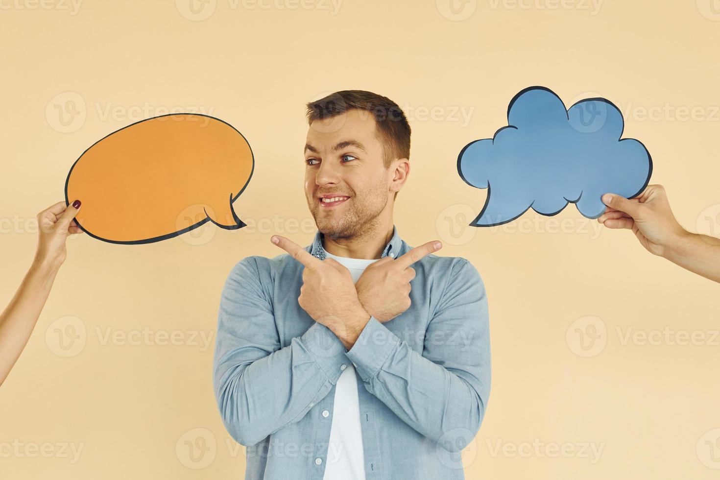 Tough choice between two ideas. Man standing in the studio with empty signs for the text photo