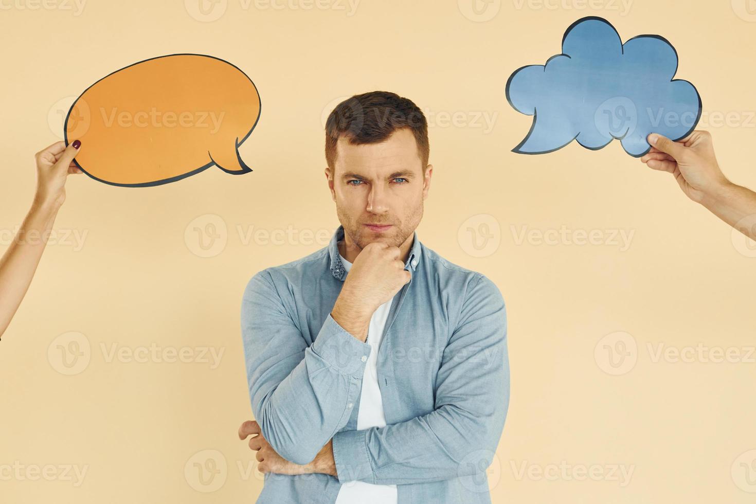 Tough choice between two ideas. Man standing in the studio with empty signs for the text photo