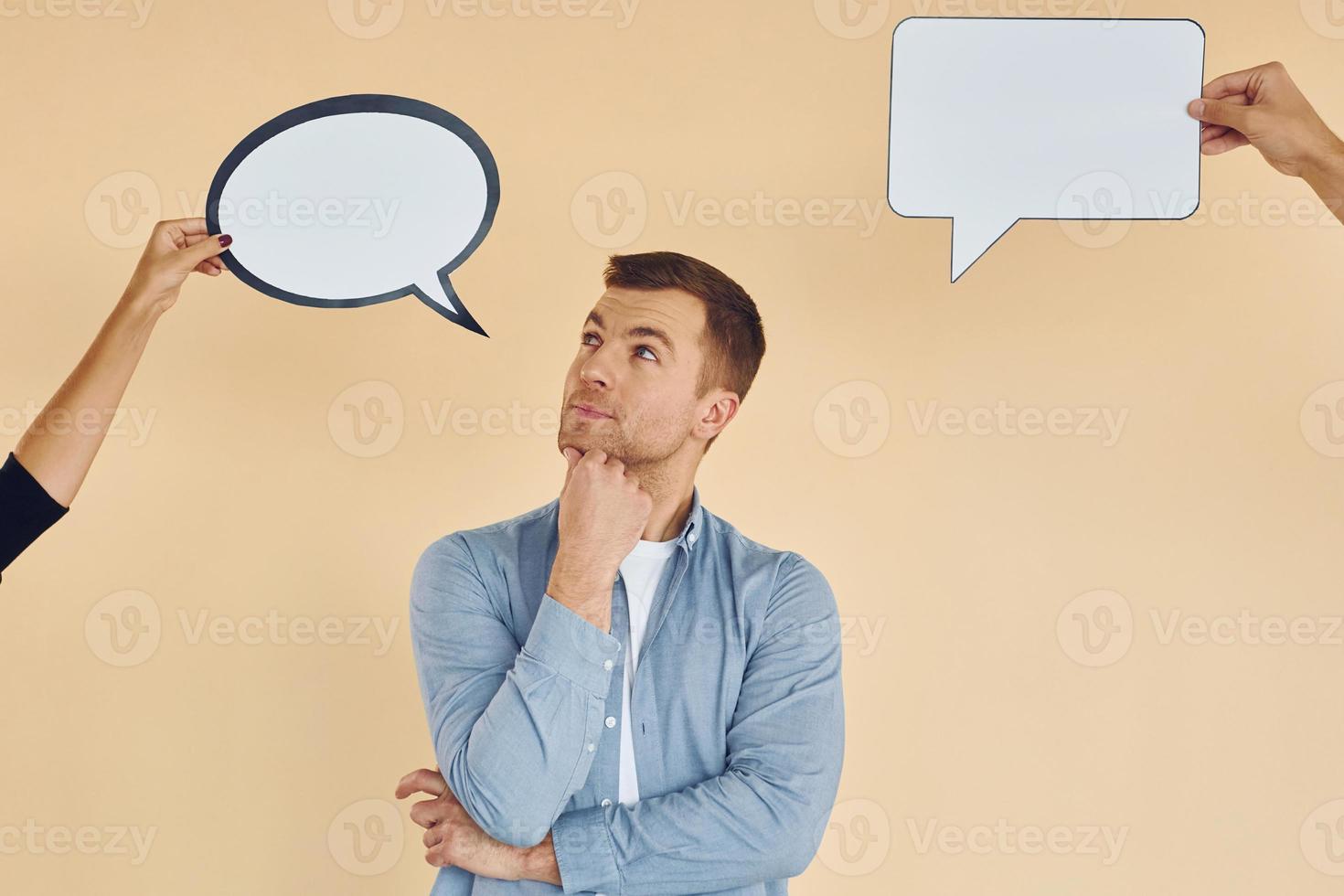 pensamientos diferentes. hombre de pie en el estudio con carteles vacíos para el texto foto