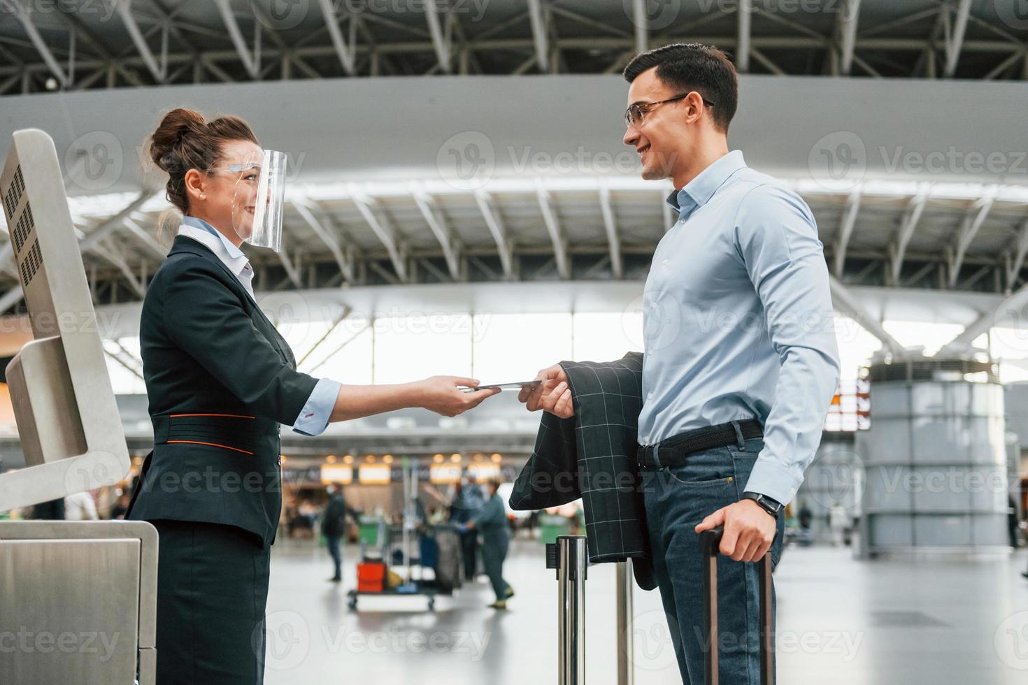 comprobación de documentos. un joven hombre de negocios con ropa formal está en el aeropuerto durante el día foto