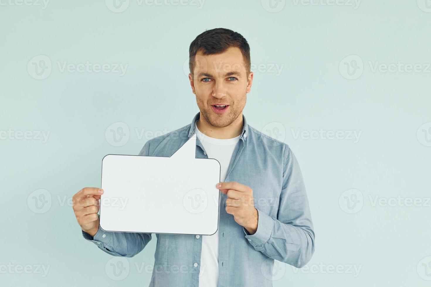 In casual clothes. Man standing in the studio with empty signs for the text photo