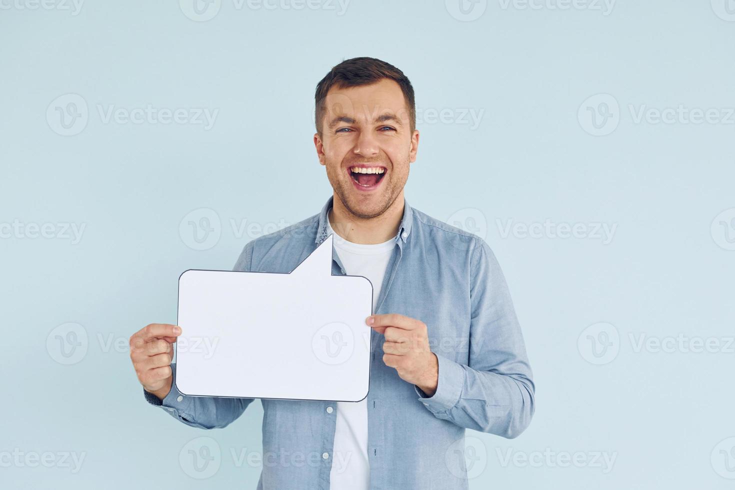 In casual clothes. Man standing in the studio with empty signs for the text photo