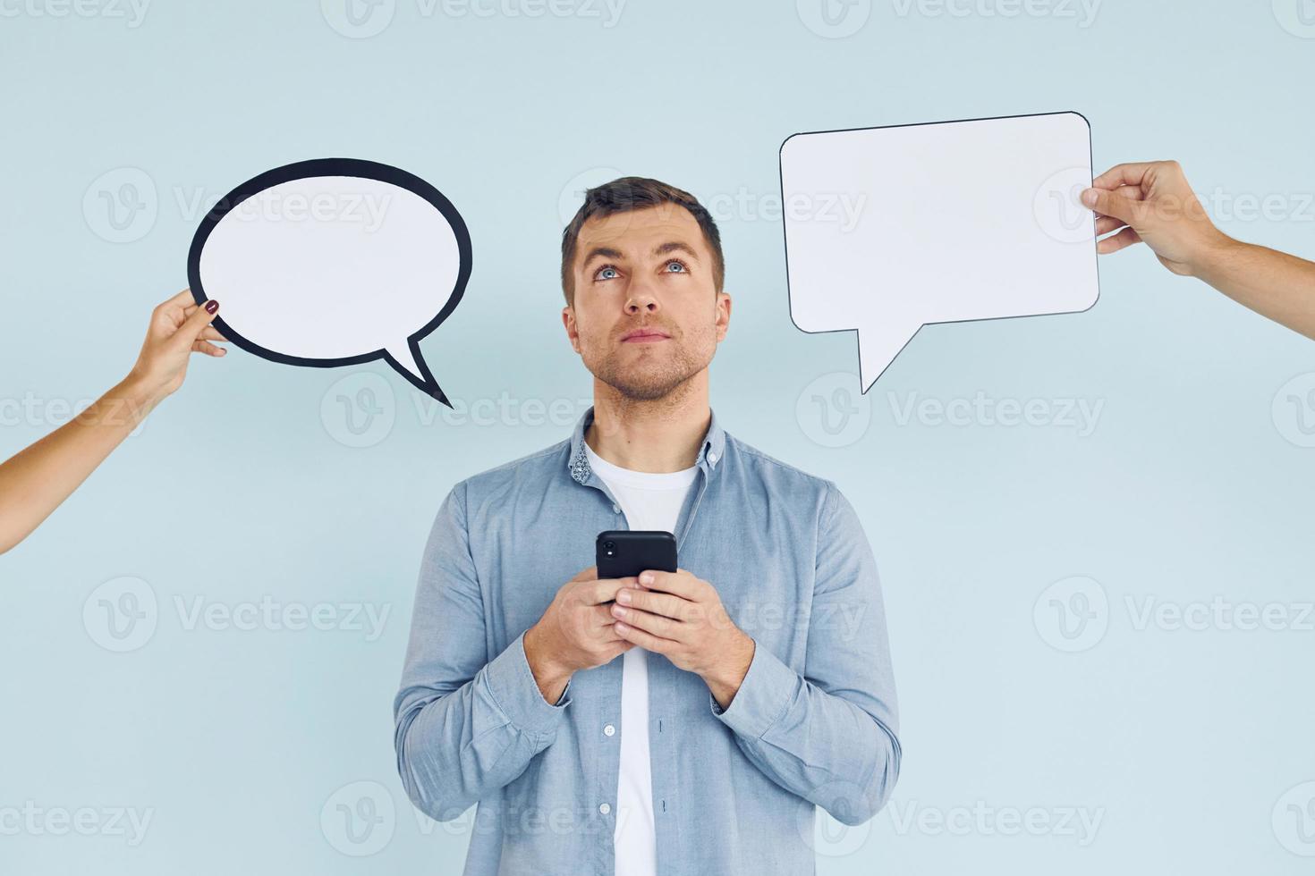 Thinking what to answer. Man standing in the studio with empty signs for the text photo