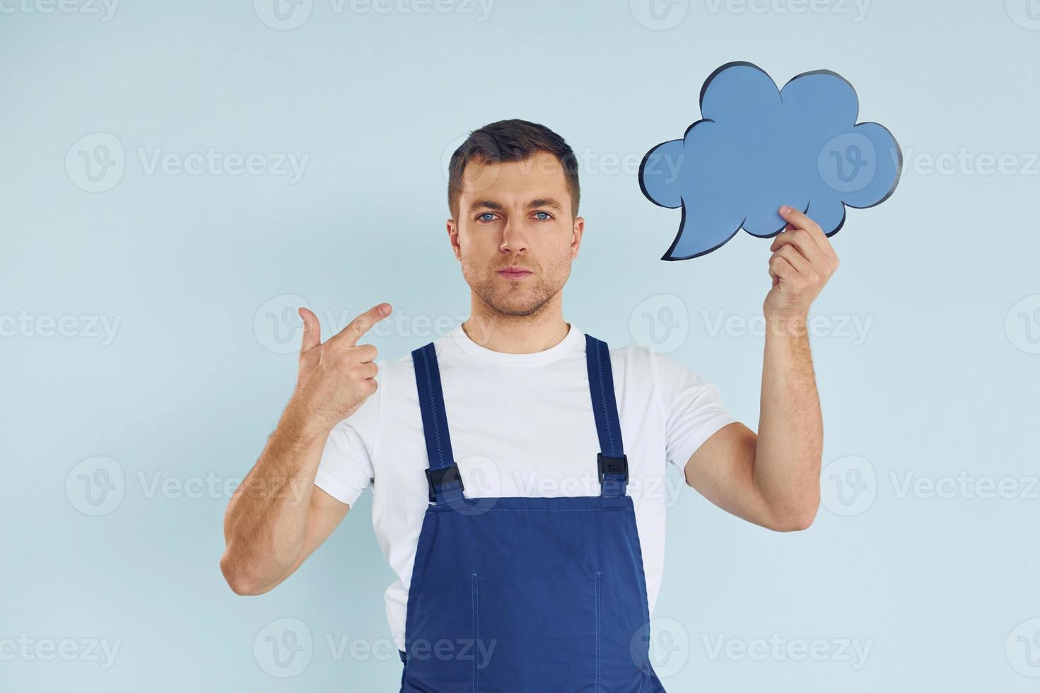 en uniforme azul. hombre de pie en el estudio con carteles vacíos para el texto foto