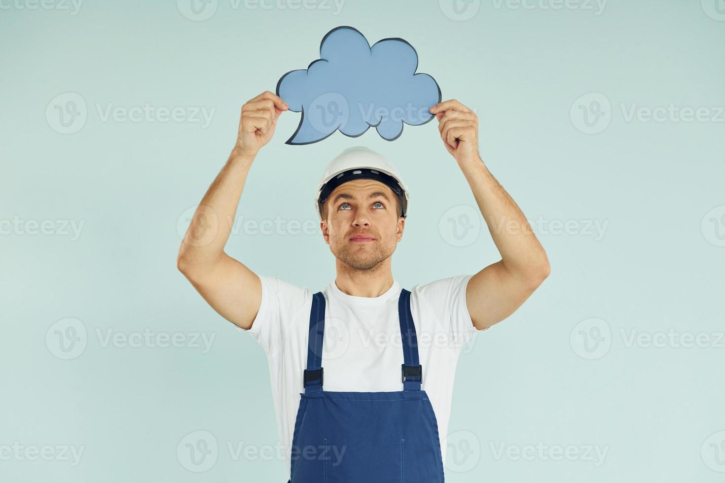 Worker in uniform. Man standing in the studio with empty signs for the text photo