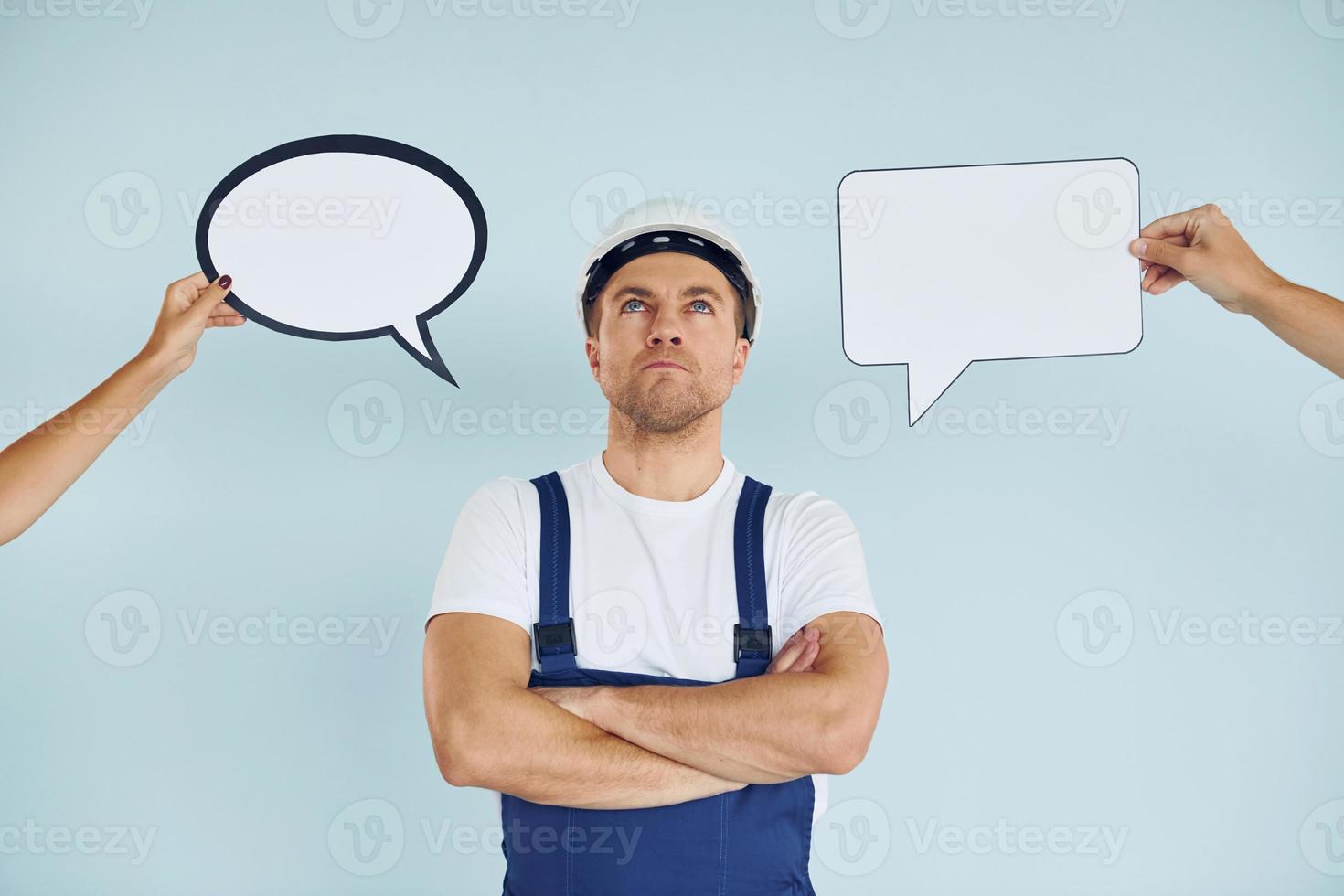 Worker is thinking. Man standing in the studio with empty signs for the text photo