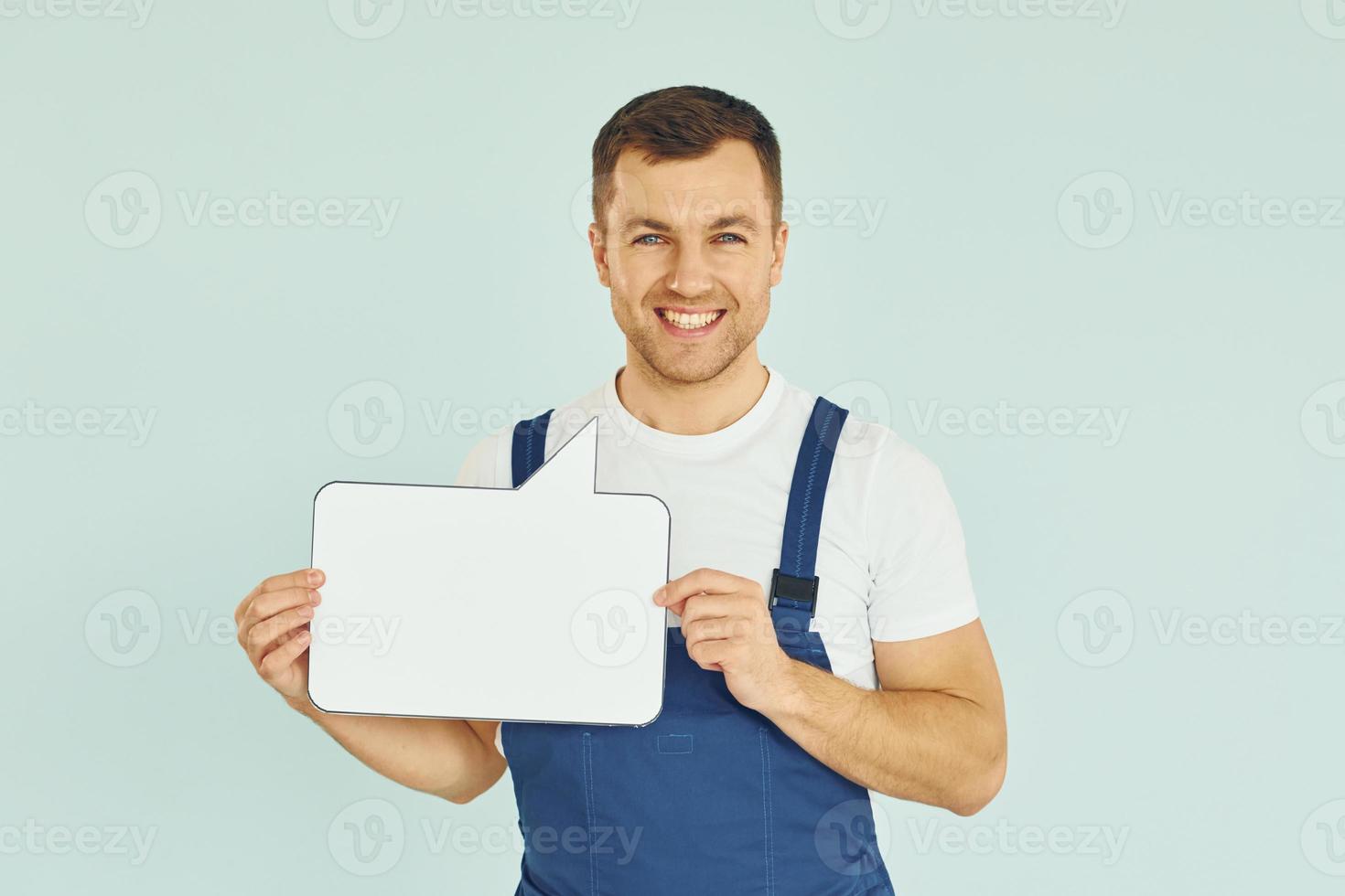 trabajador diciendo algo. hombre de pie en el estudio con carteles vacíos para el texto foto