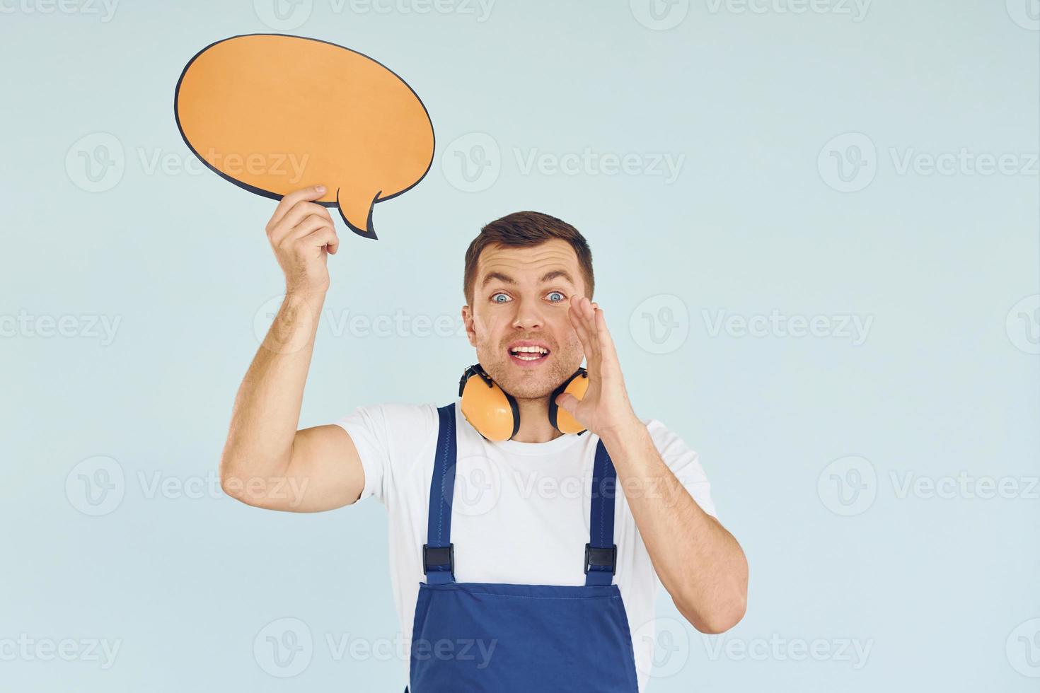 con grandes auriculares en el cuello. hombre de pie en el estudio con carteles vacíos para el texto foto