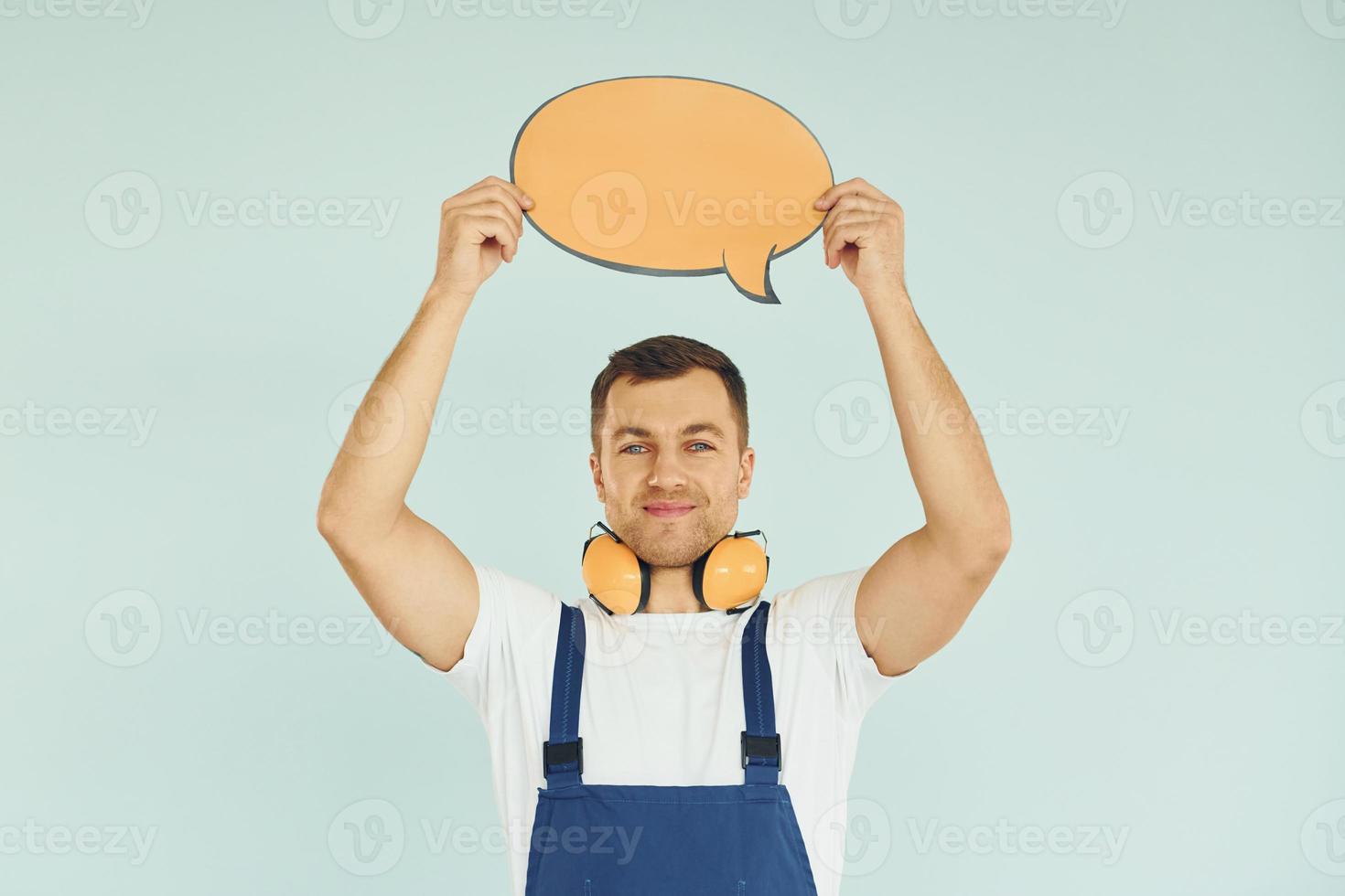 con grandes auriculares en el cuello. hombre de pie en el estudio con carteles vacíos para el texto foto