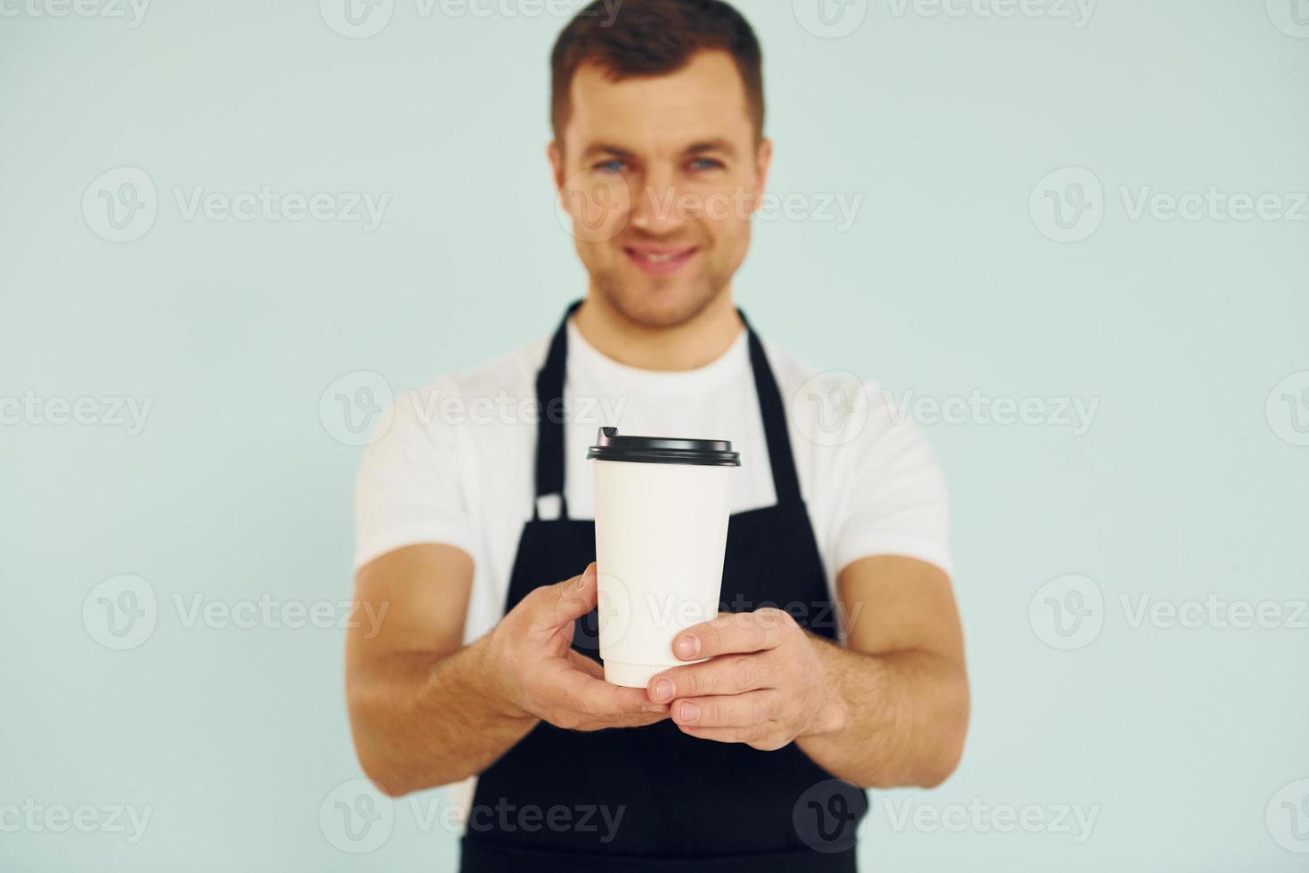 Man in uniform standing in the studio with drink in hands photo