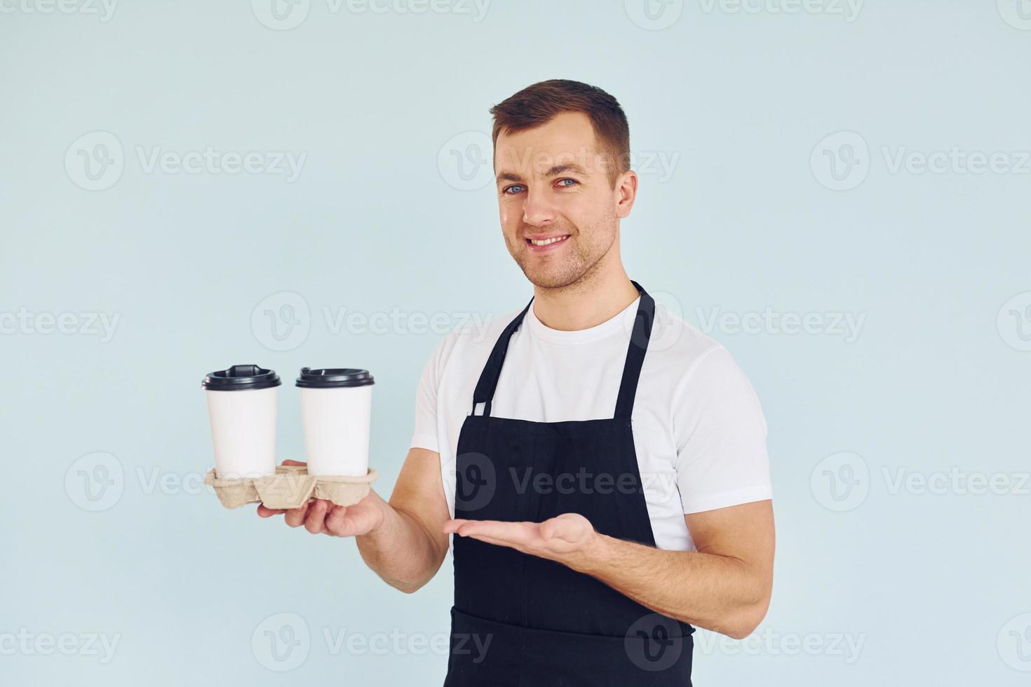 Man in uniform standing in the studio with drinks in hands photo