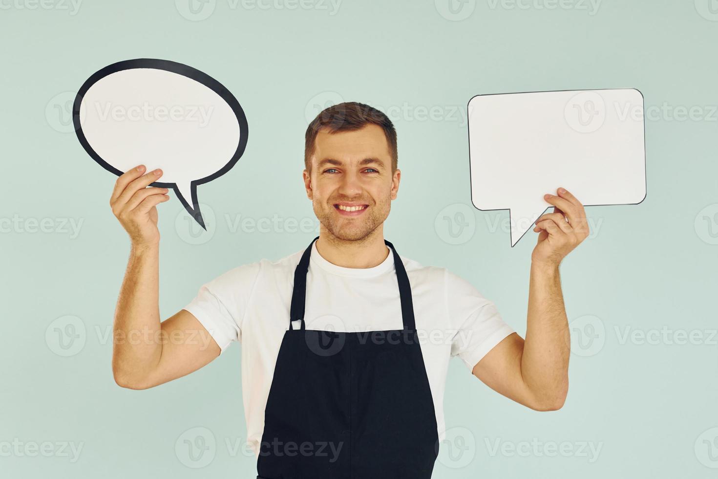 Hard choice between two ideas. Man standing in the studio with empty signs for the text photo