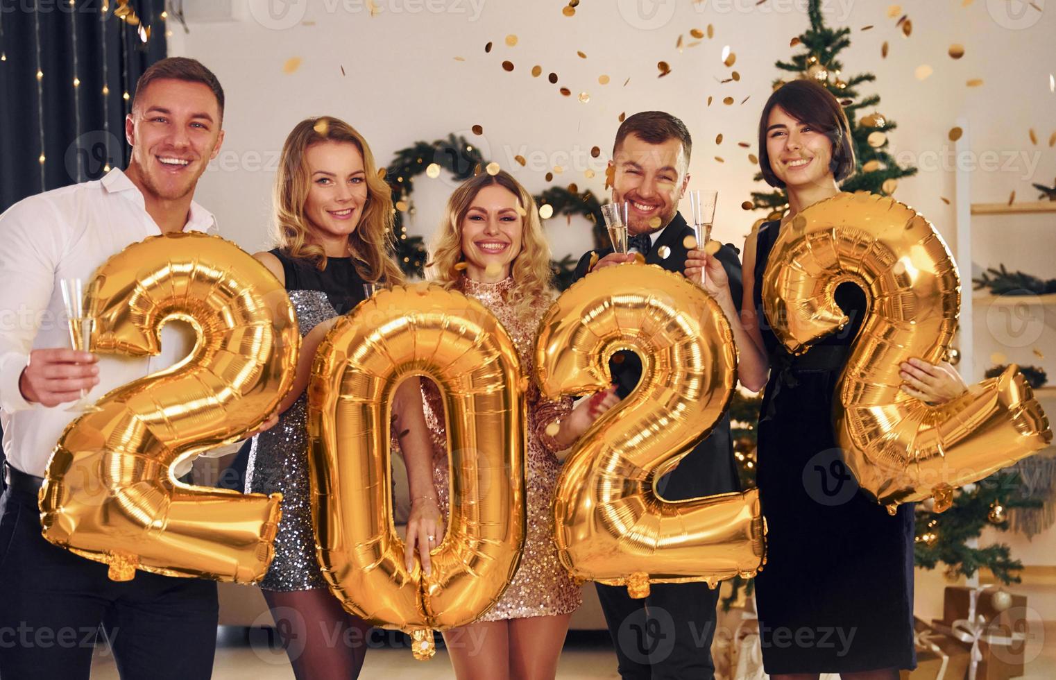 2022 año. grupo de personas tienen una fiesta de año nuevo en el interior juntos foto
