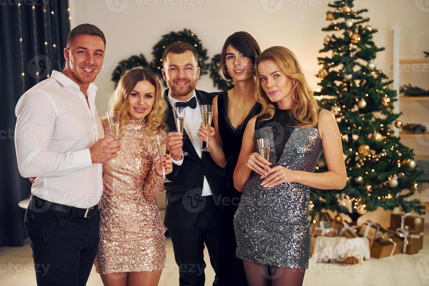 X-mas holidays. Group of people have a new year party indoors together photo