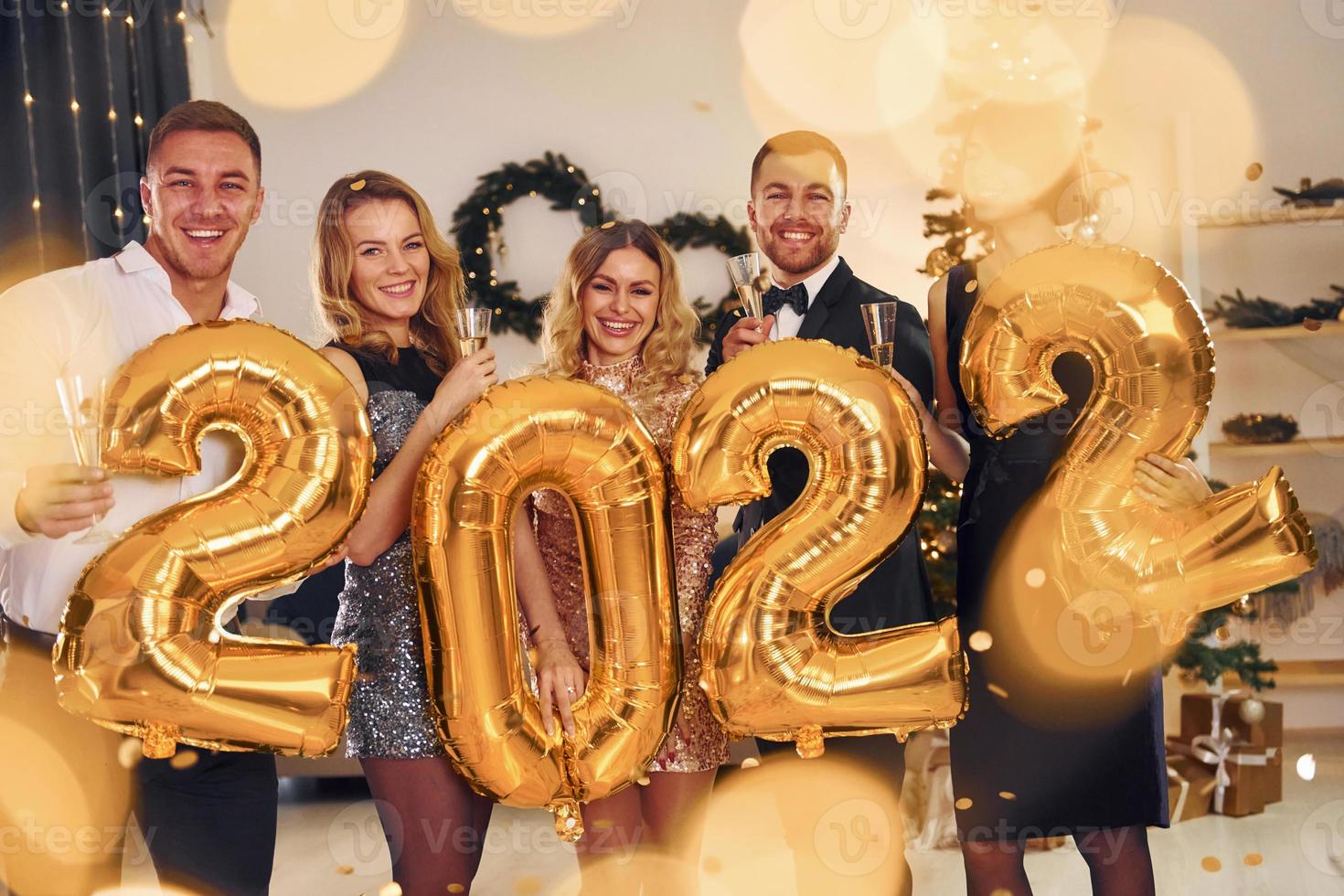 2022 año. grupo de personas tienen una fiesta de año nuevo en el interior juntos foto