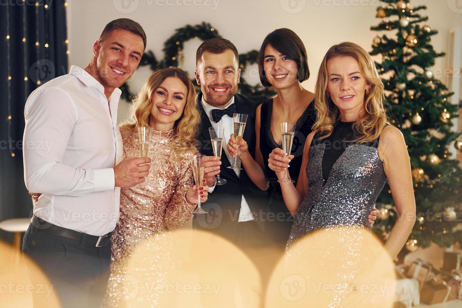 X-mas holidays. Group of people have a new year party indoors together photo