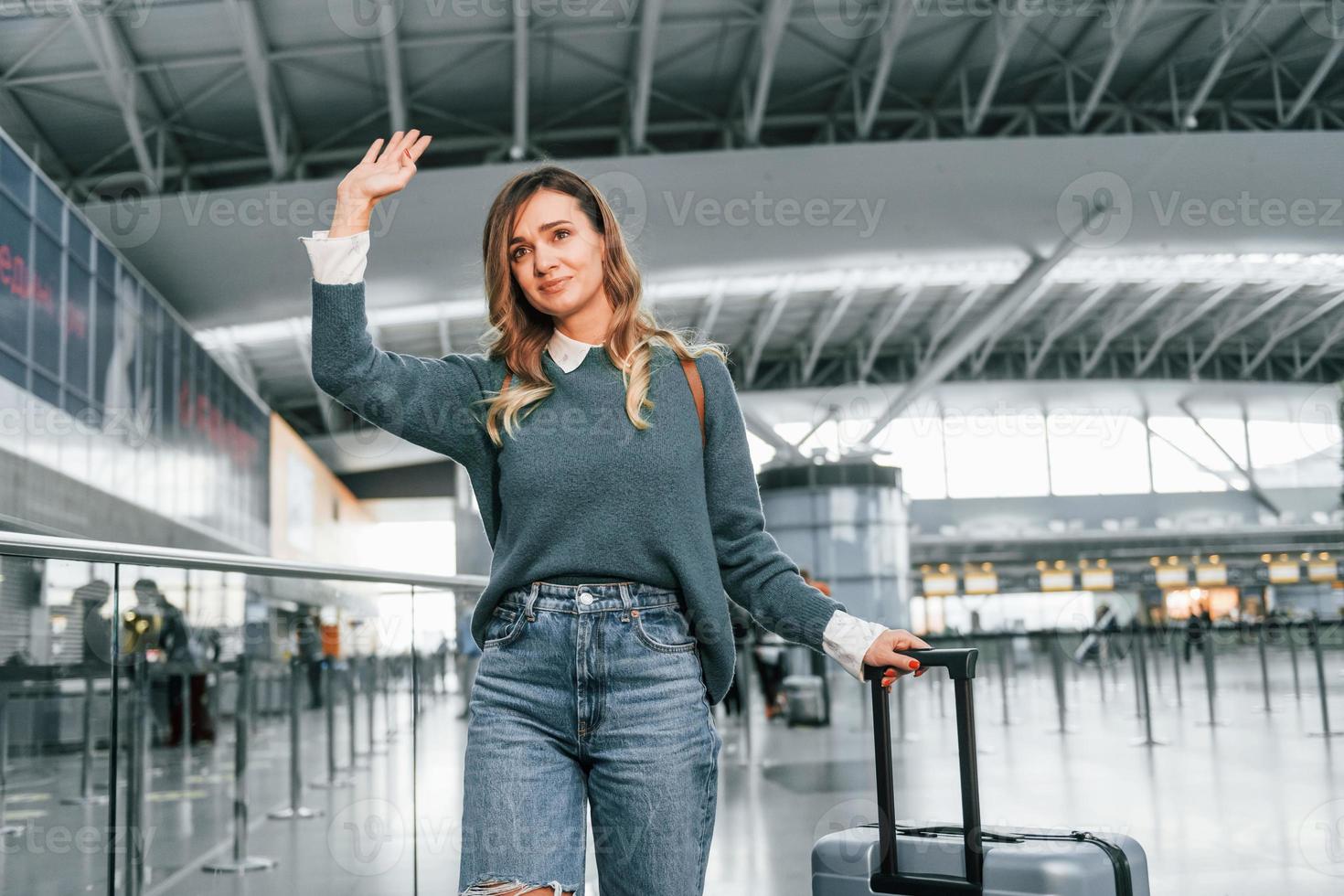 hola gesto. joven turista está en el aeropuerto durante el día foto