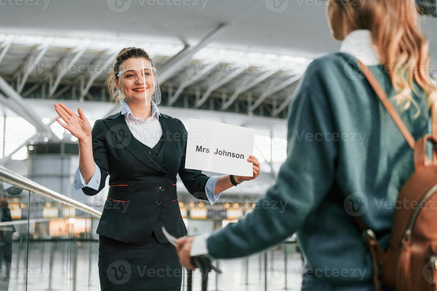 Woman with plate with text. Young female tourist is in the airport at daytime photo