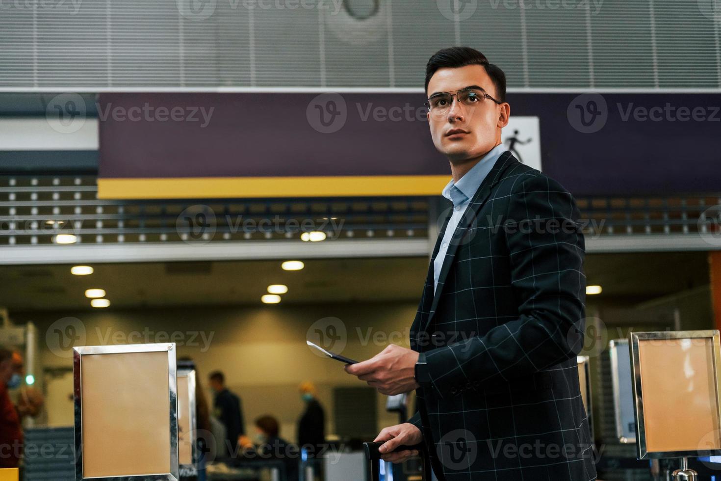 Modern background. Young businessman in formal clothes is in the airport at daytime photo