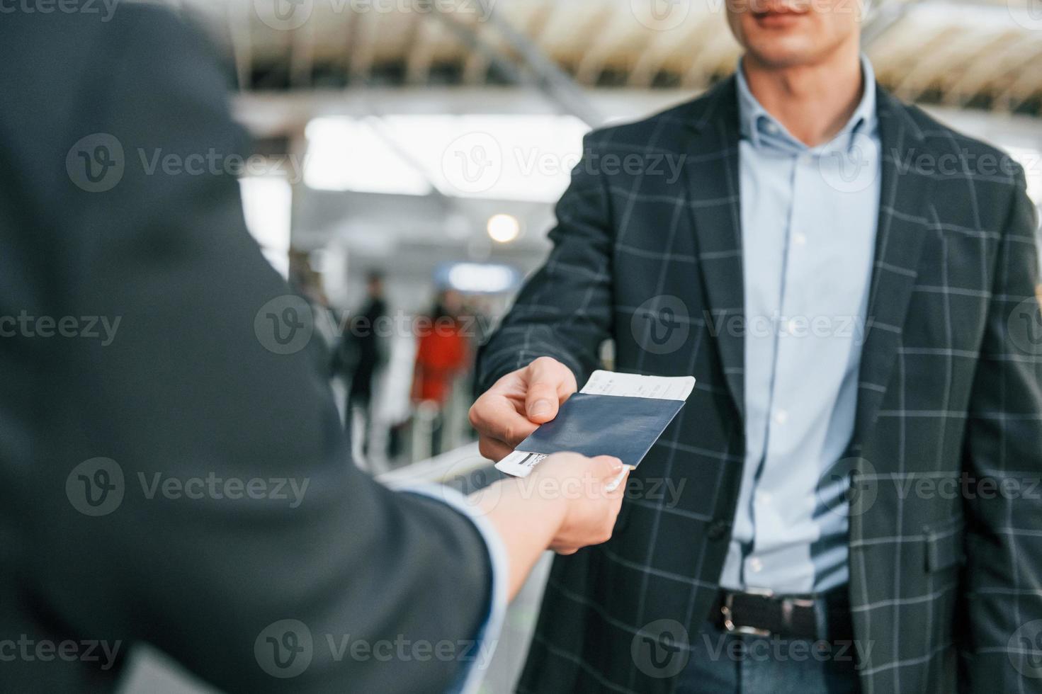 Working with documents. Young businessman in formal clothes is in the airport at daytime photo