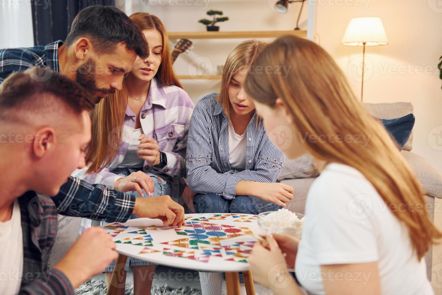 jugando un juego inteligente. grupo de amigos tienen una fiesta en el interior juntos foto