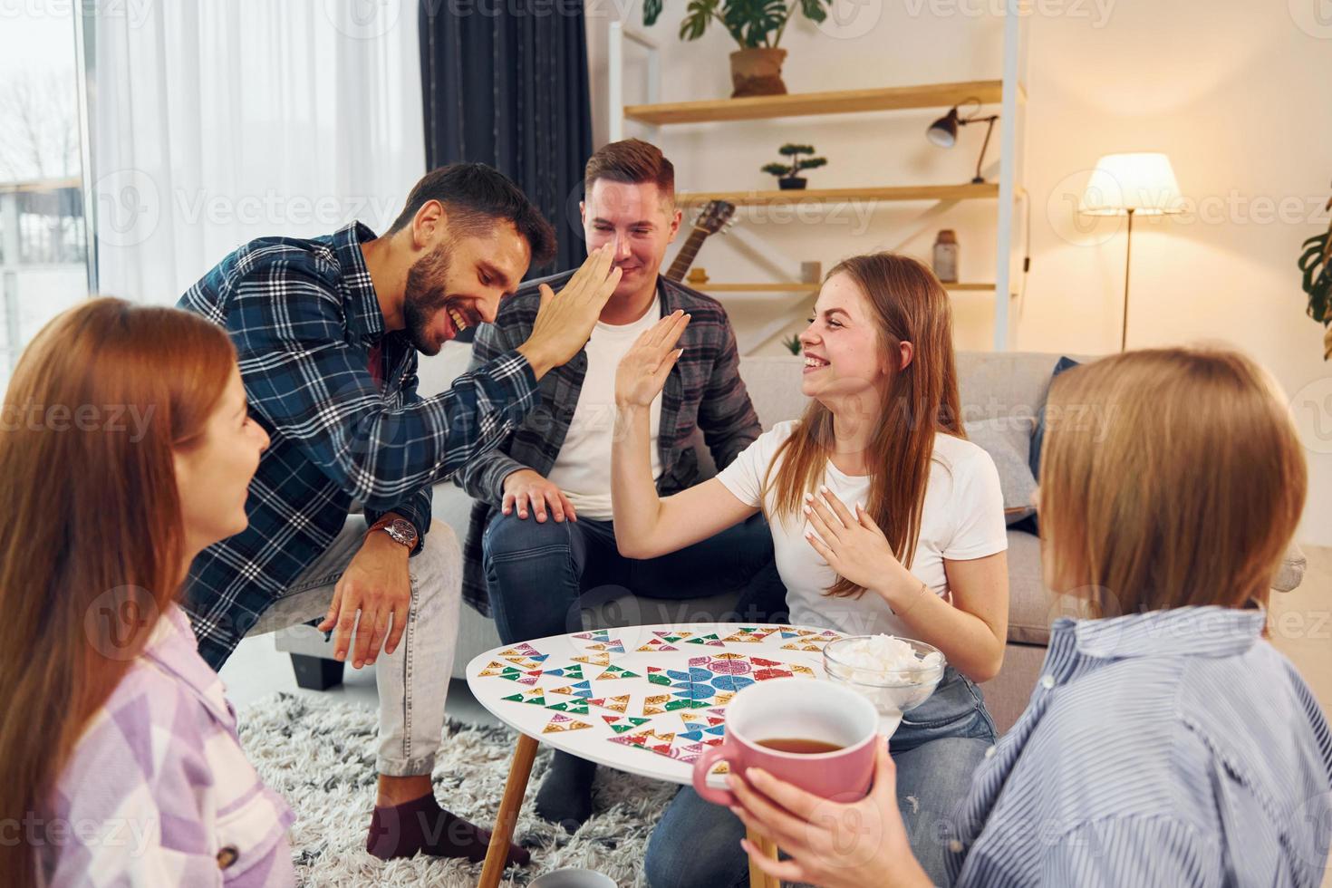 Playing smart game. Group of friends have party indoors together photo