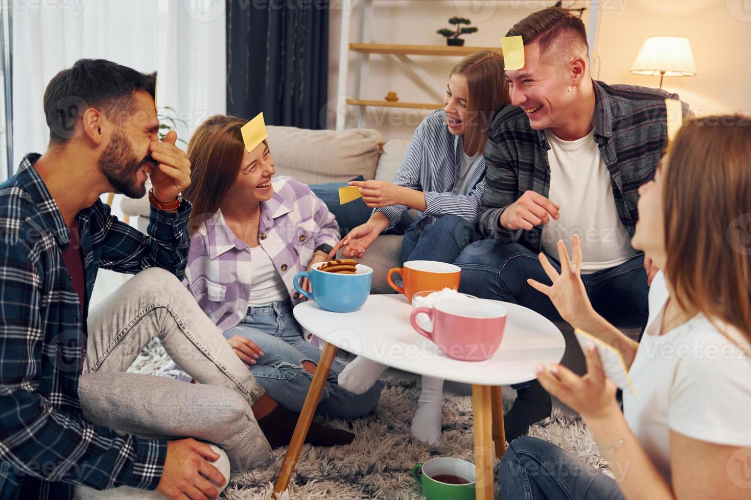 Trying to guess who I am. Group of friends have party indoors together photo