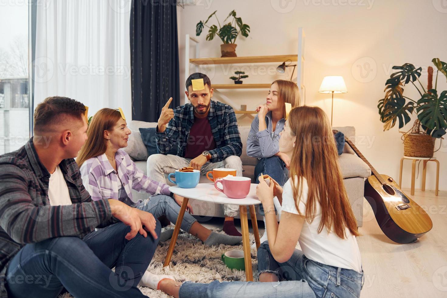 Trying to guess who I am. Group of friends have party indoors together photo