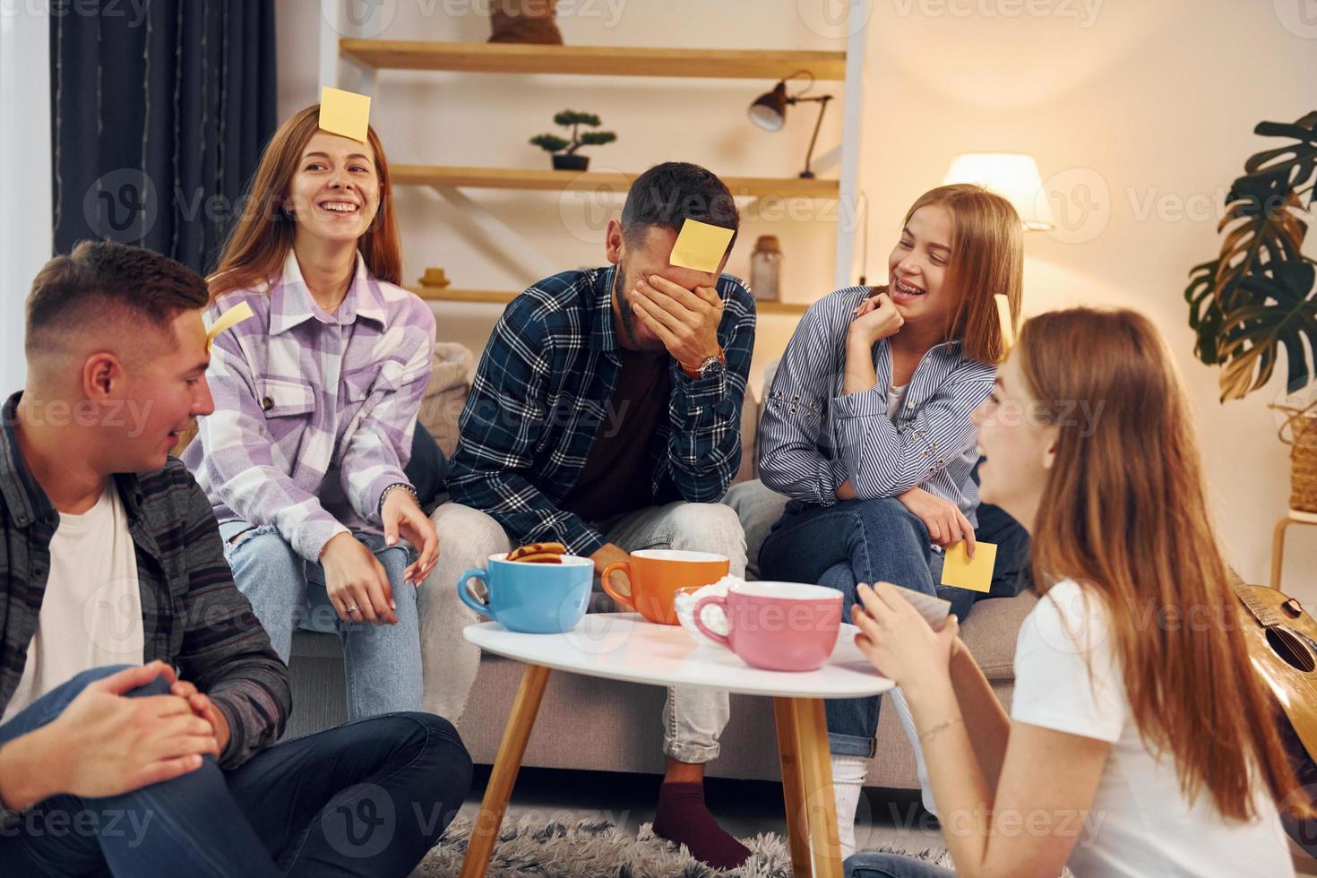 Trying to guess who I am. Group of friends have party indoors together photo
