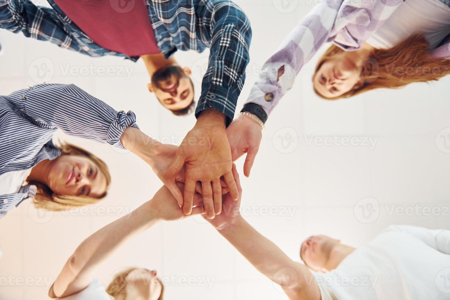 Holding each other's hands. Group of friends standing together photo