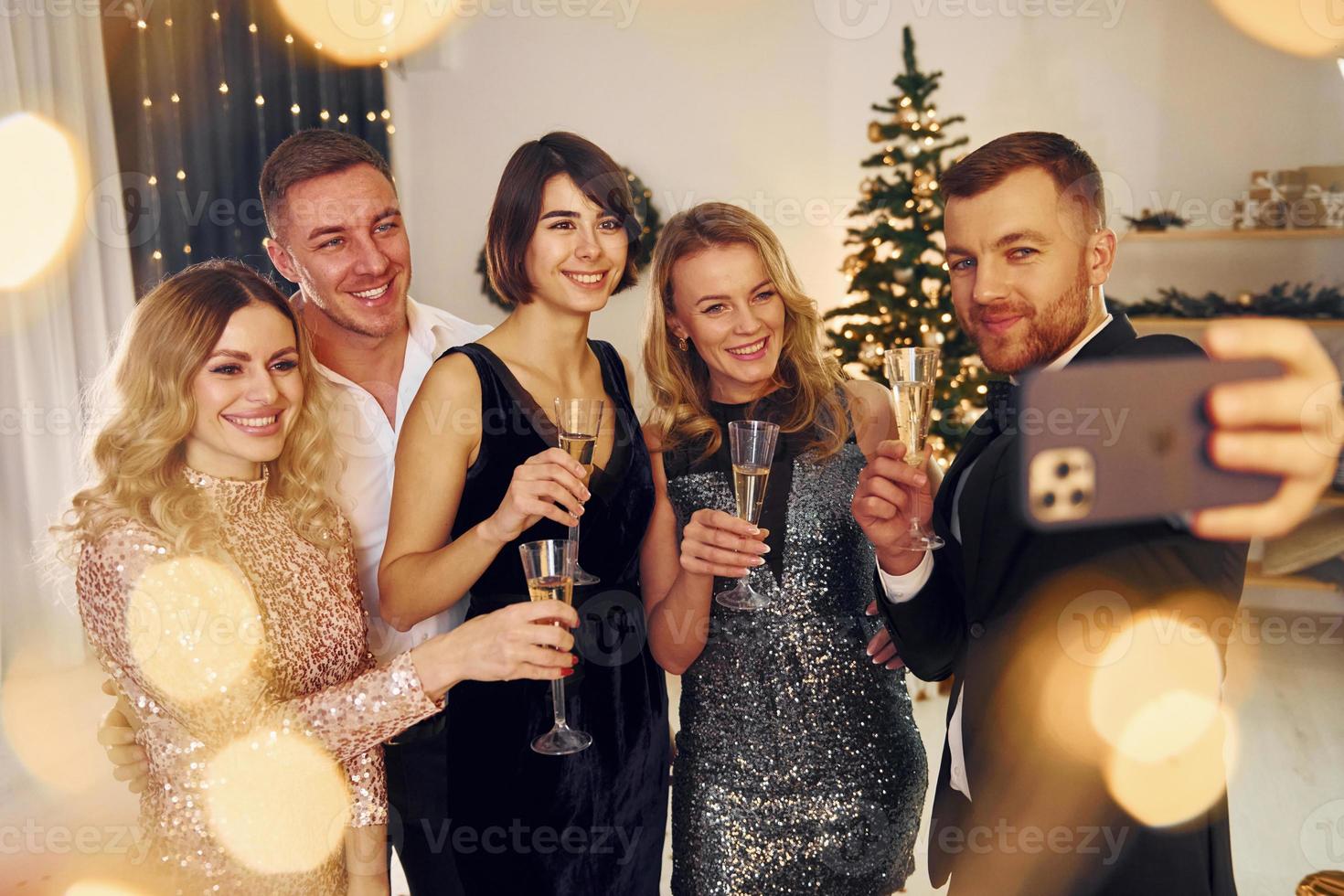 emociones positivas. grupo de personas tienen una fiesta de año nuevo en el interior juntos foto