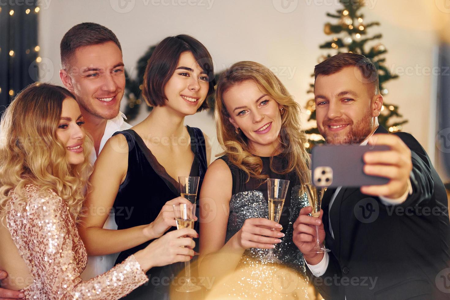 haciendo selfie grupo de personas tienen una fiesta de año nuevo en el interior juntos foto