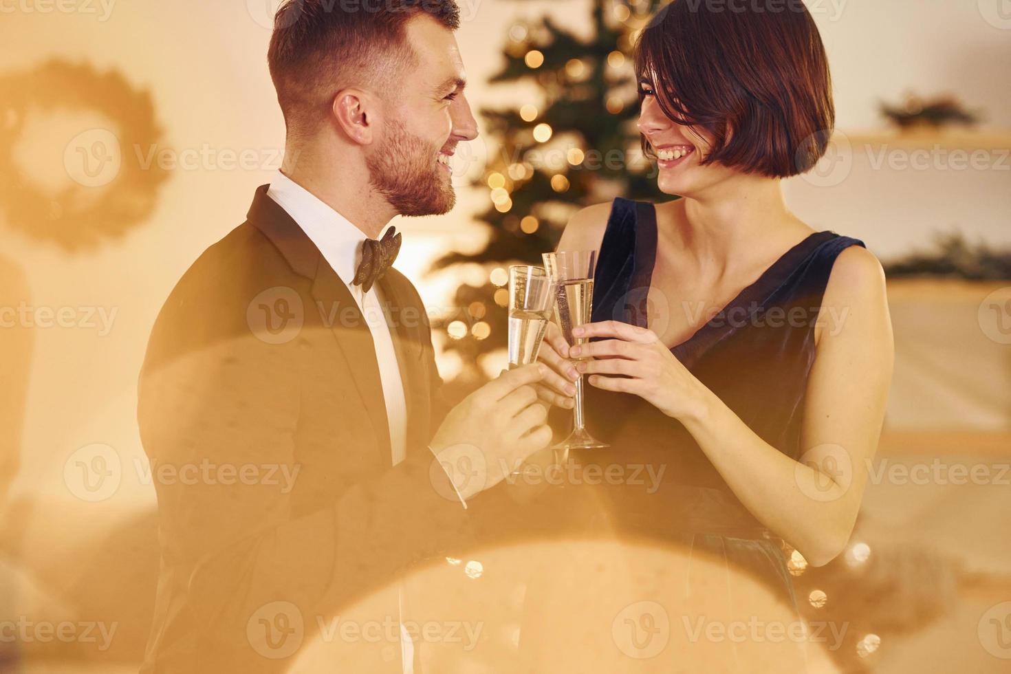 iluminado por luz amarilla. pareja feliz tiene una fiesta de año nuevo en el interior juntos foto