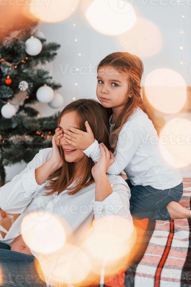 Having fun. Mother with her little daughter is having fun indoors on the bed photo