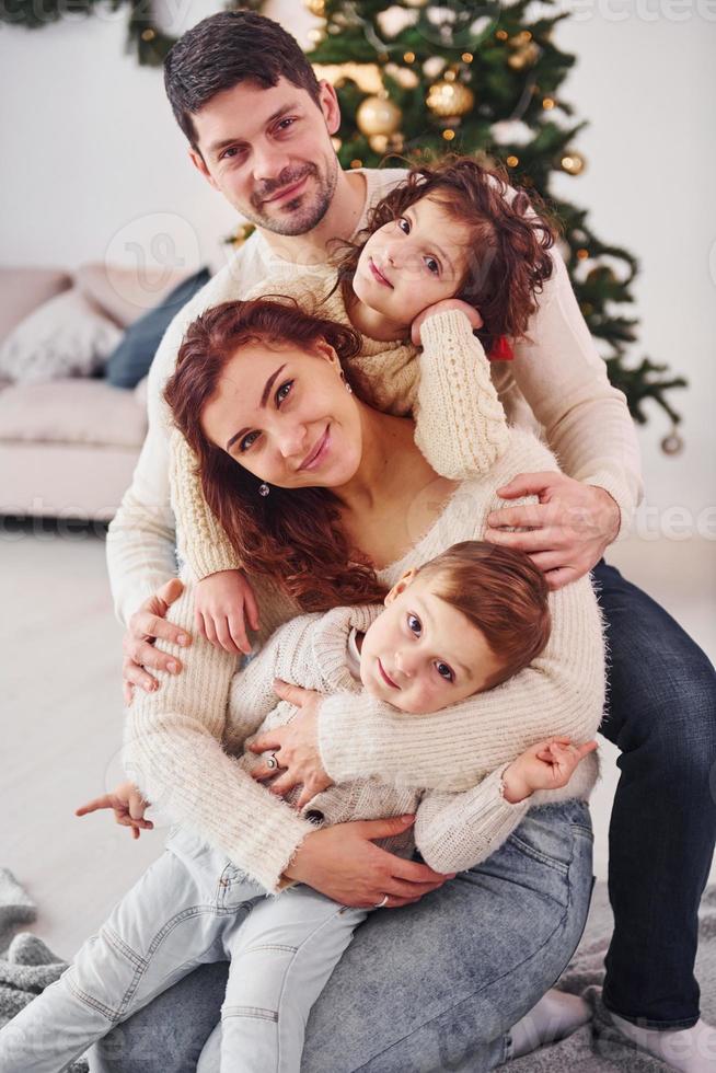Posing for the camera. Family celebrating new year with their children at home photo