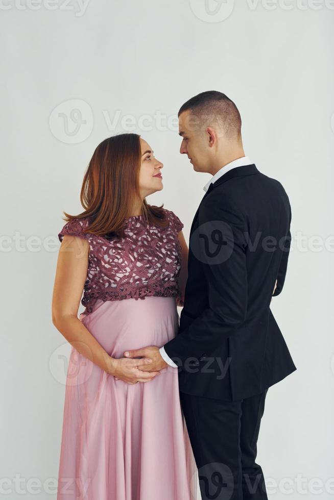 Couple in formal clothes standing in the studio with white background photo