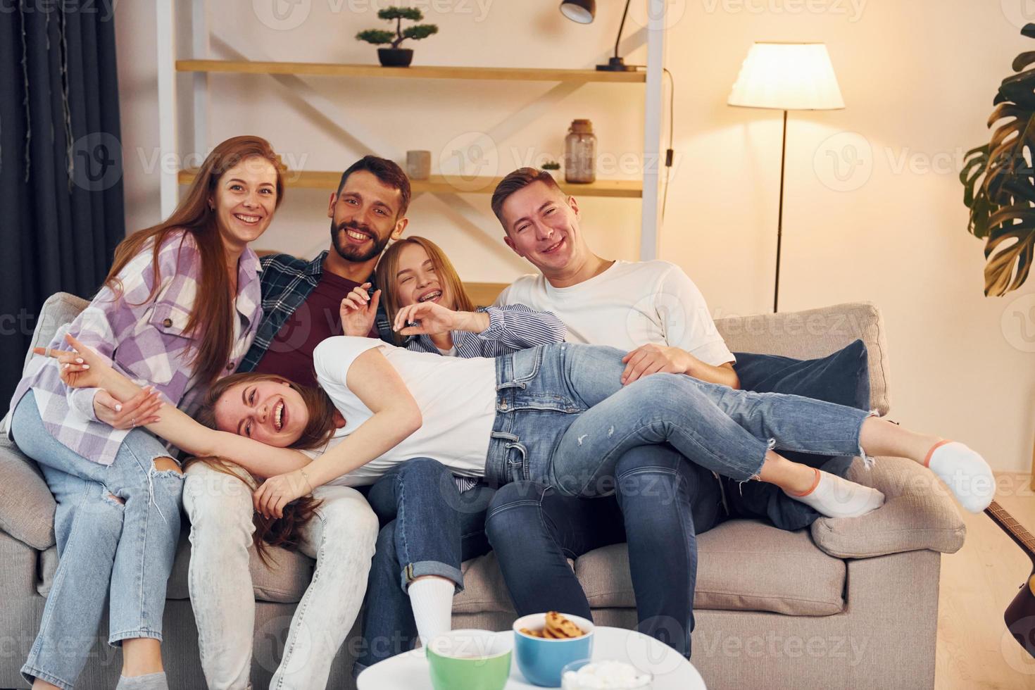 Spending weekend together. Group of friends have party indoors together photo