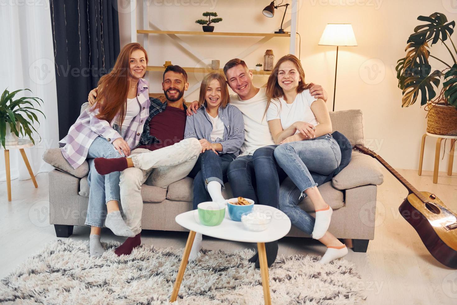 pasar el fin de semana juntos. grupo de amigos tienen una fiesta en el interior juntos foto